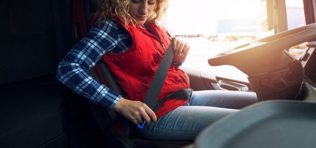 Truck driver fastening seat belt for safety. Buckle up. Safe and secure.