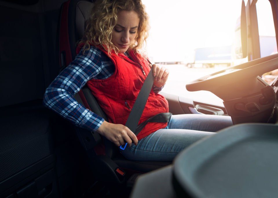 Truck driver fastening seat belt for safety. Buckle up. Safe and secure.