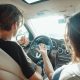 man driving with woman in passenger seat