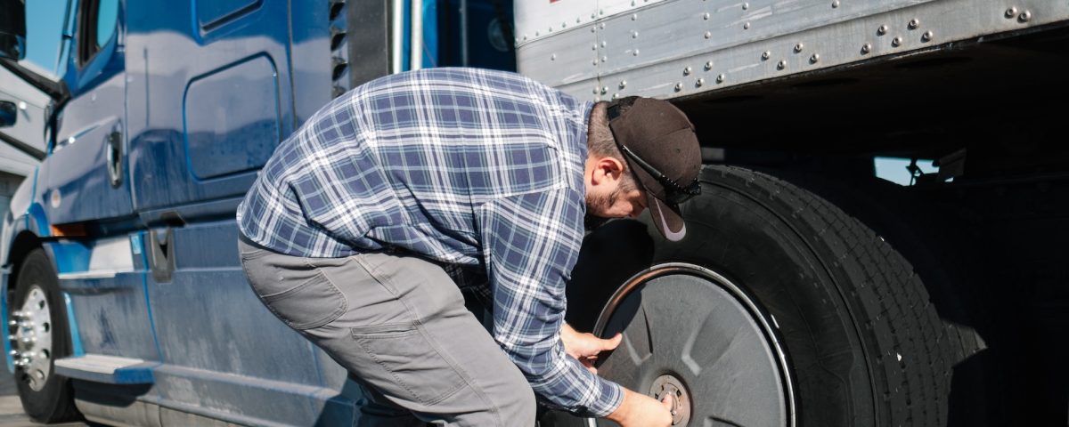 truck driver checking truck tire