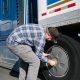 truck driver checking truck tire