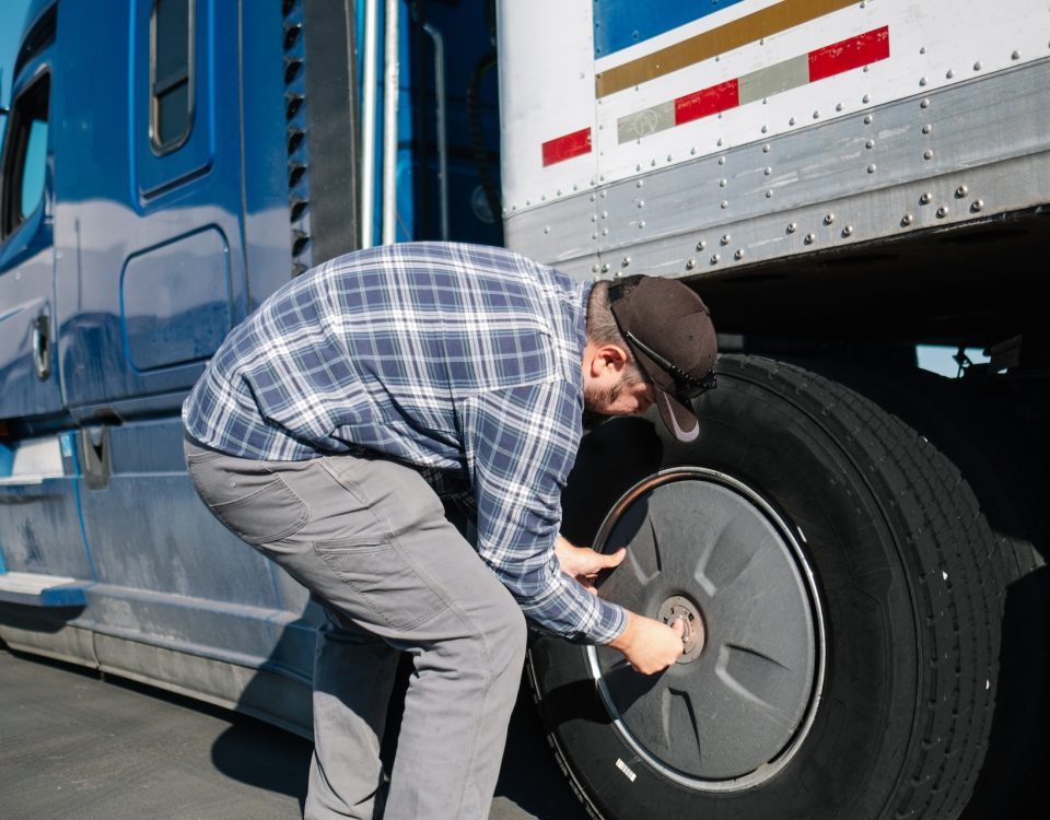 truck driver checking truck tire